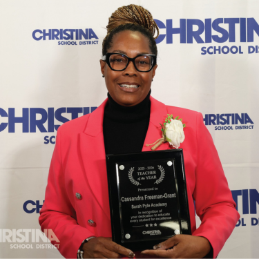 Photo of Cassandra Freeman-Grant Sarah Pyle Academy 2025-2026 Teacher of the Year holding plaque